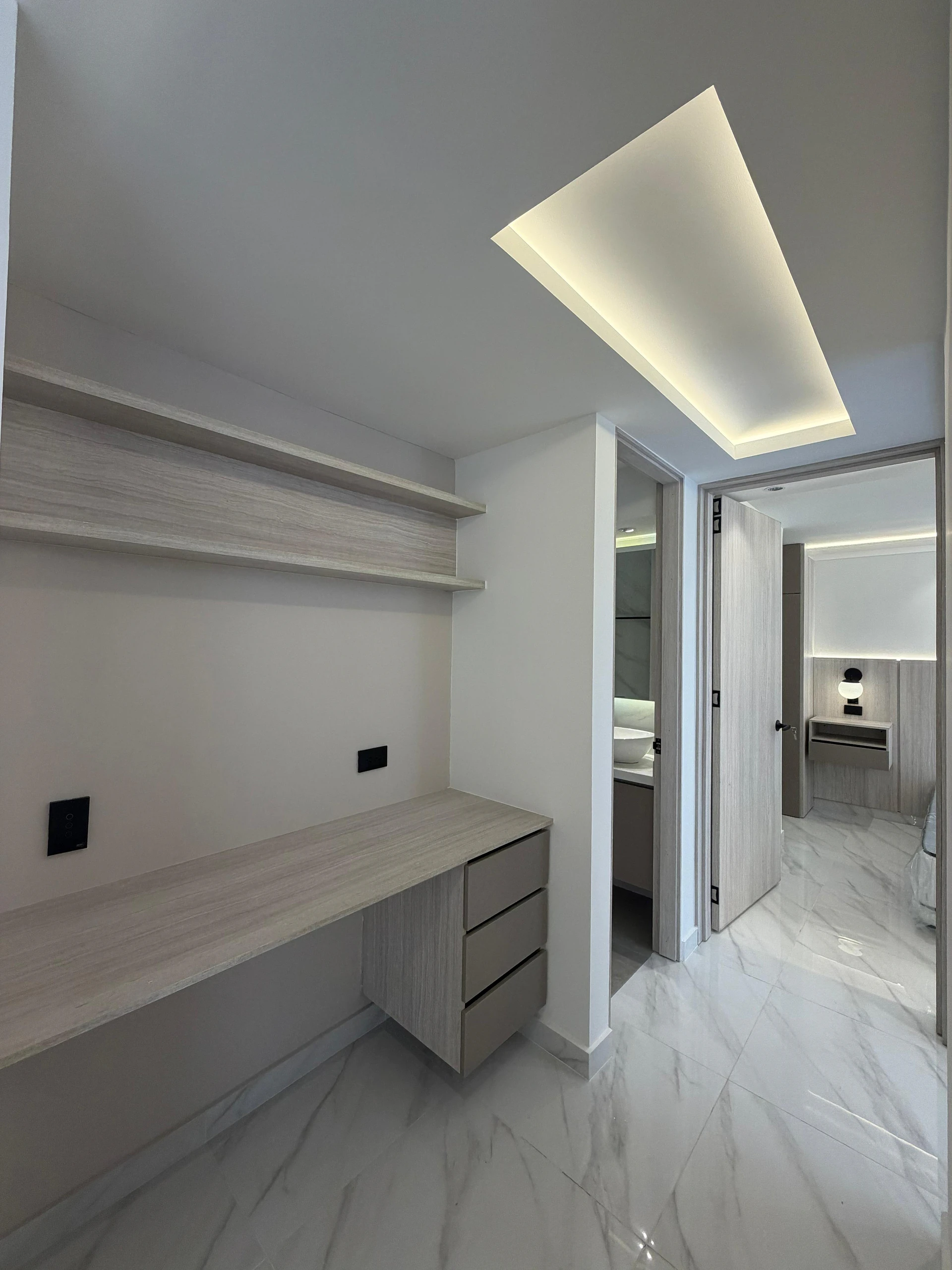 Escritorio a medida en roble con luz de cielo y piso de mármol