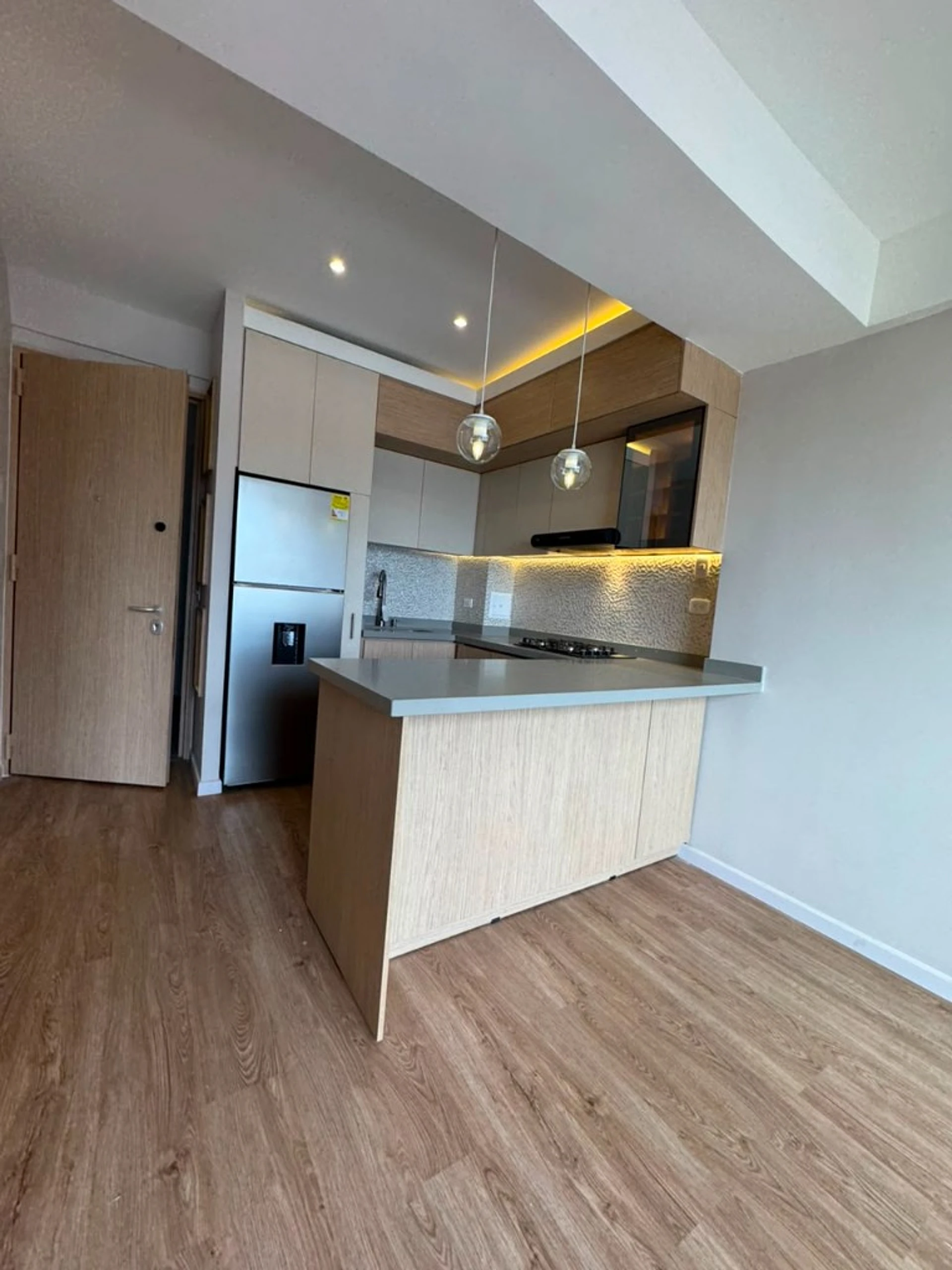 Cocina a medida en roble claro con isla en un apartamento en Bogotá