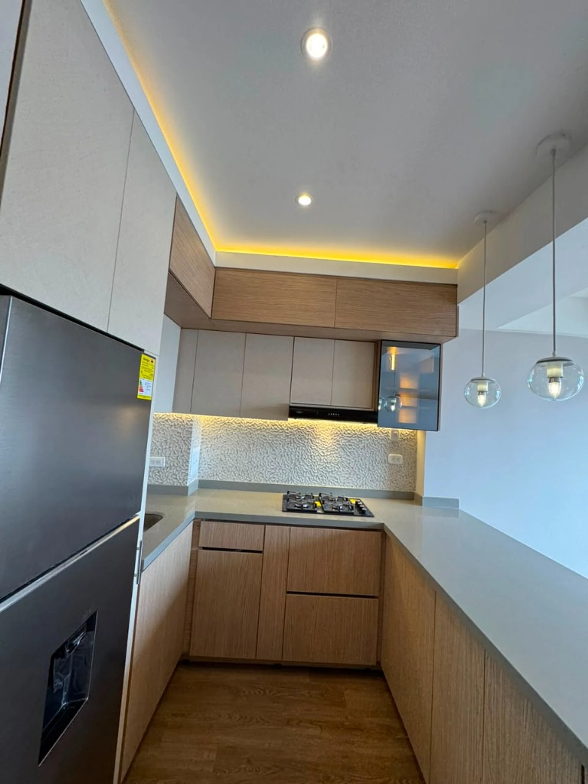 Cocina en roble con salpicadero texturizado, LED y cubierta gris