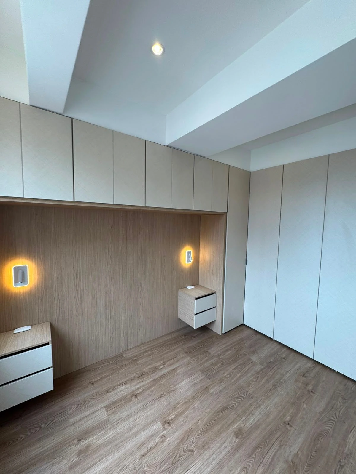 Habitación con closet a medida, veladores flotantes y luz cálida