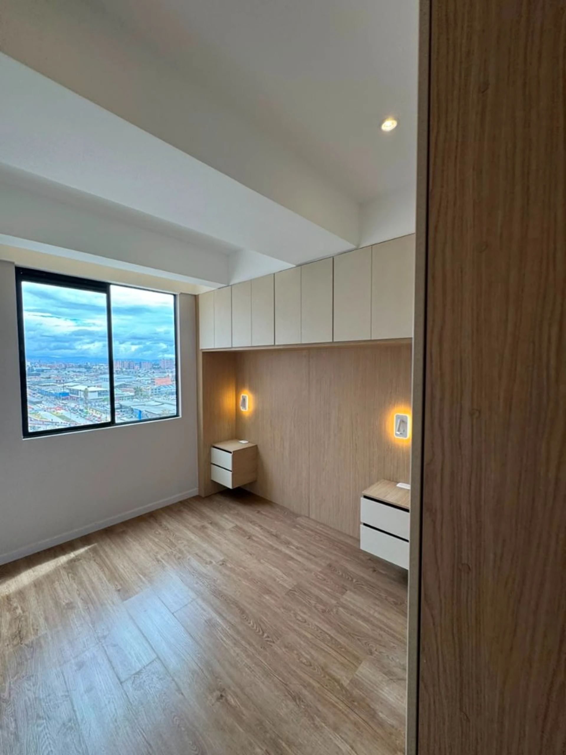 Habitación con veladores flotantes, clóset aéreo y vista de Bogotá